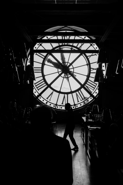 a person standing in front of a large clock