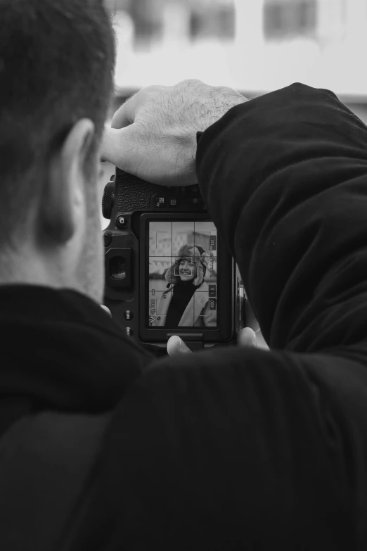 a black and white po of a person taking a picture with a camera