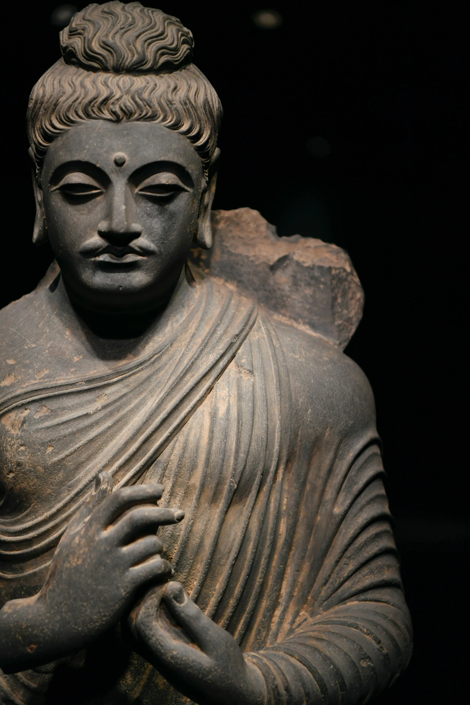 an ancient statue sitting in a dark room