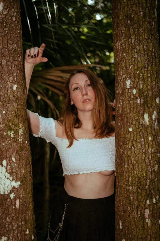 a woman with  standing next to tall trees