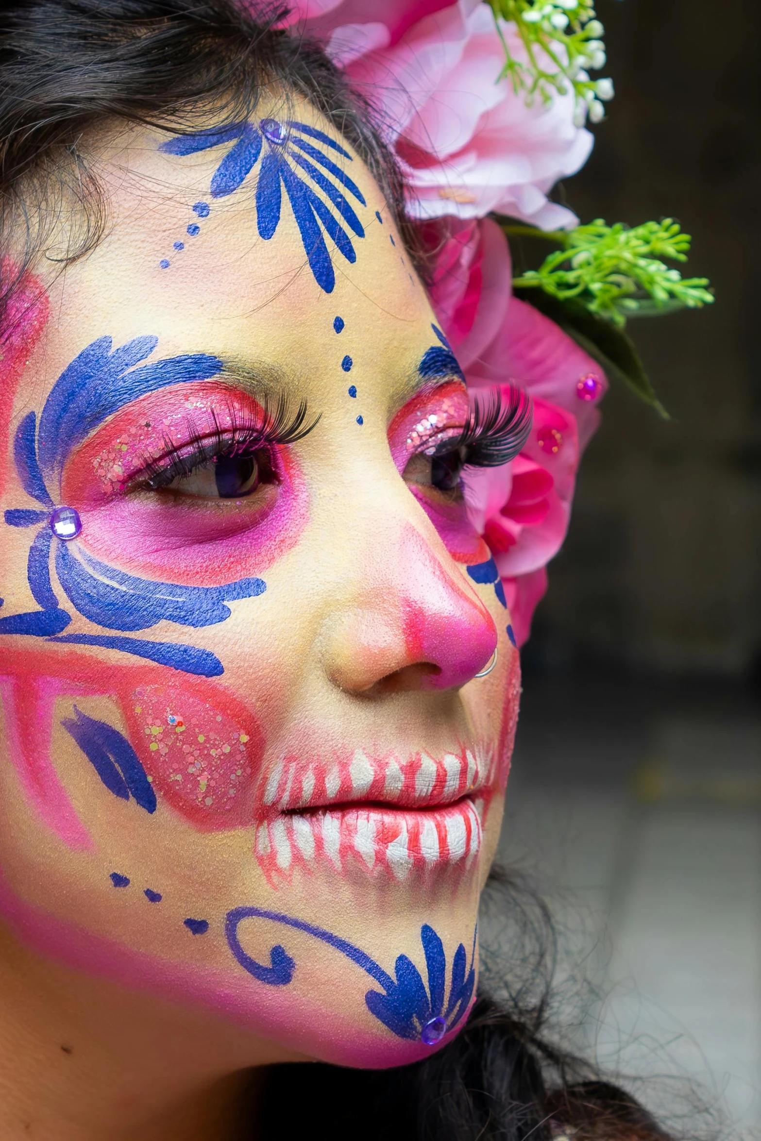 a woman with pink, blue and purple face paint