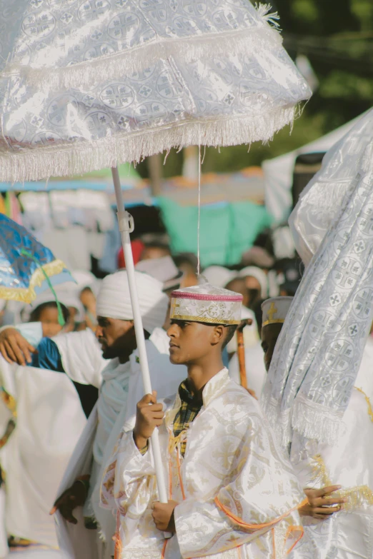 a man in white is holding an umbrella