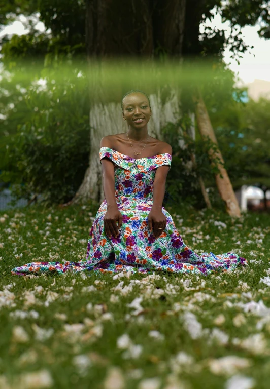 a woman wearing an abstractally colored dress in the middle of some grass and flowers