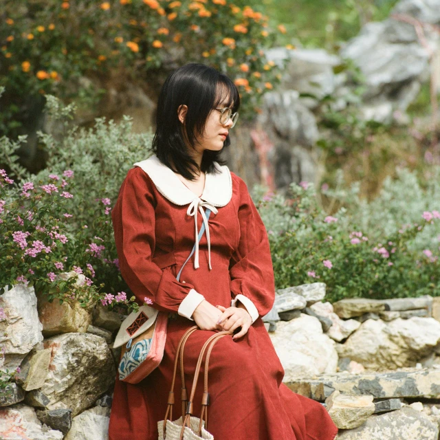 a woman in a red dress is holding a handbag