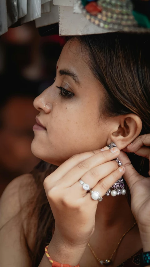 a close up of a person wearing a necklace and earring