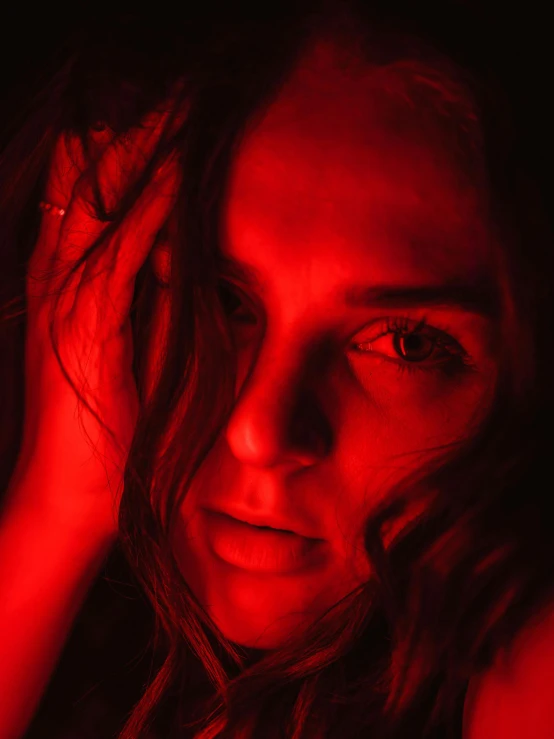 a woman looking into the camera in red light