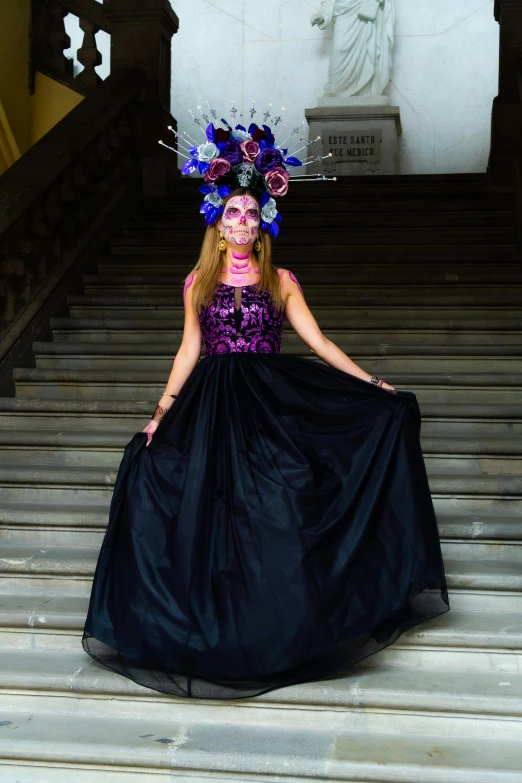 a woman standing on top of stairs in a black dress