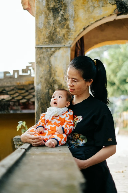 woman in black shirt holding up her baby