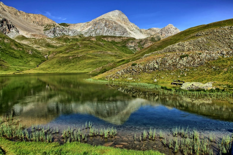 a small lake with mountains in the background