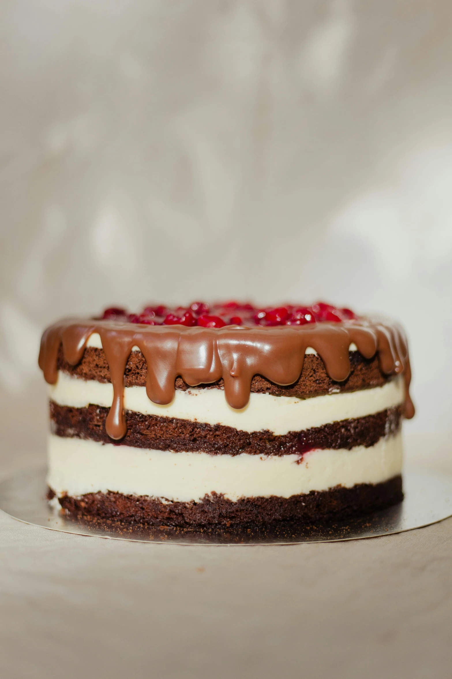 chocolate and cream frosted cake with cherries on top