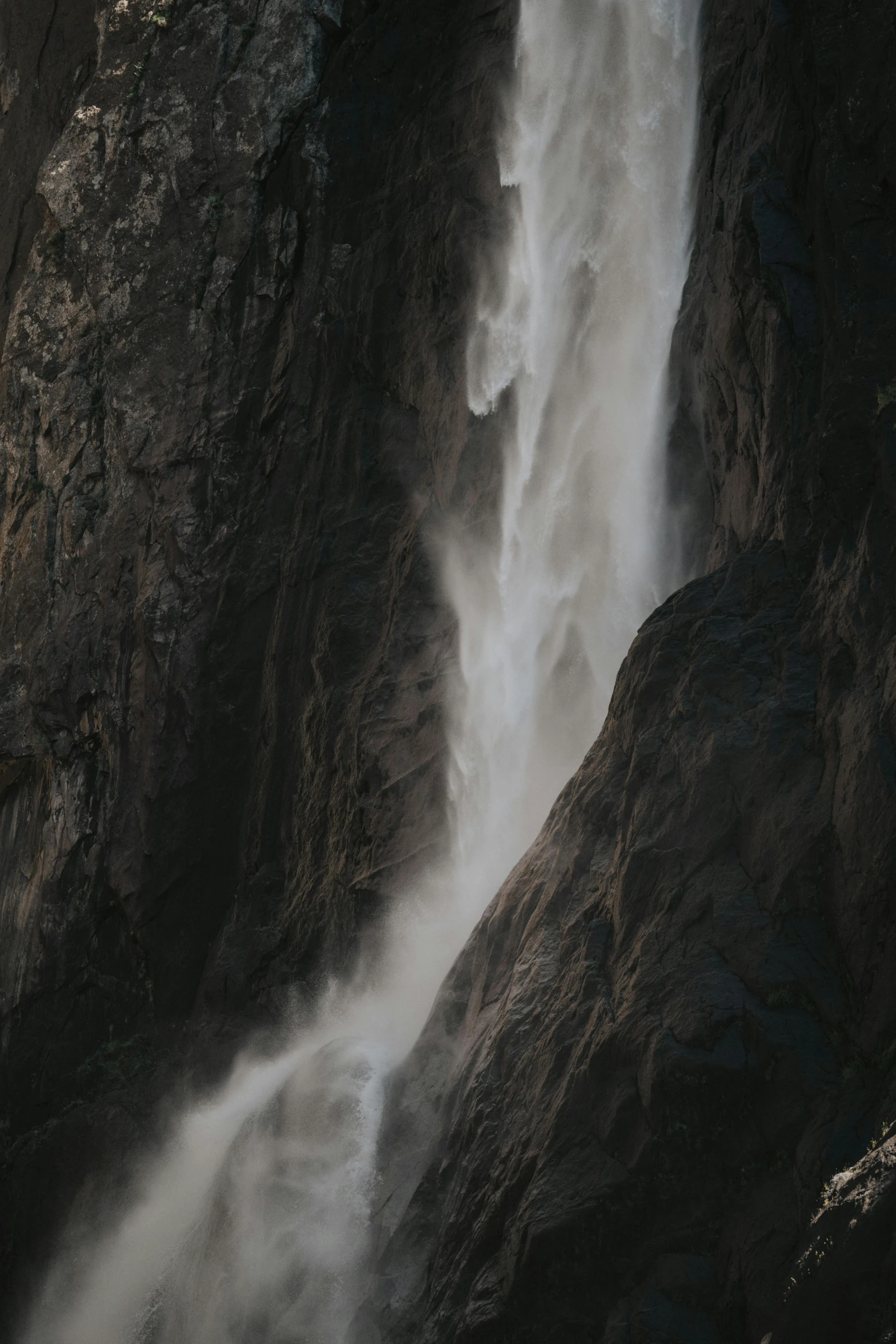 a waterfall falling down a rocky cliff in the mountains