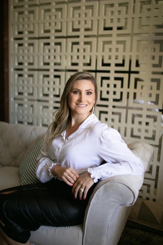 a woman is posing on a couch with her arms crossed