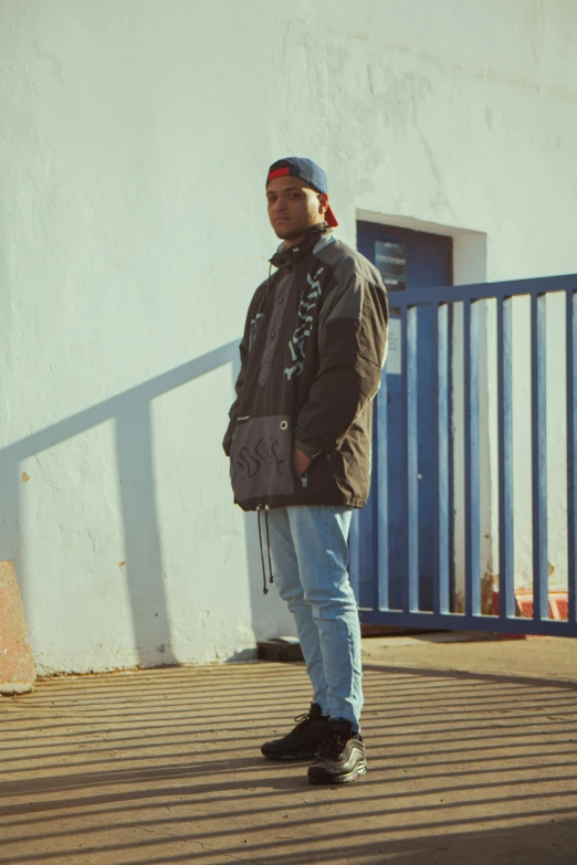 a man is standing on the side walk with his hand in his pockets