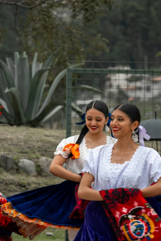 two women are performing in front of some flowers