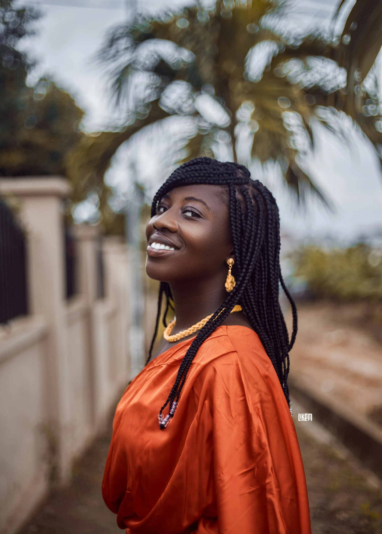 a woman is standing in front of a fence