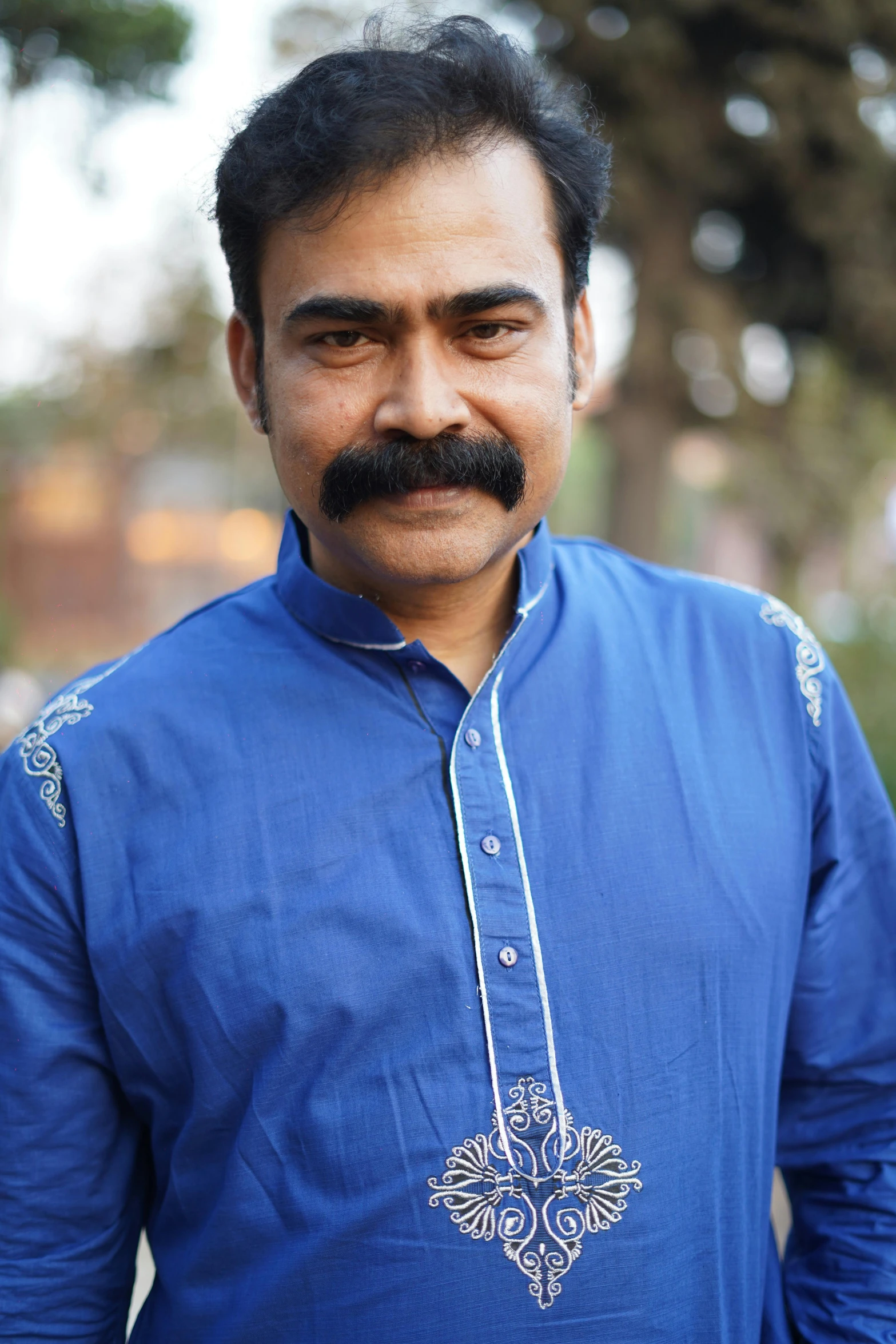 a man with a mustache and blue shirt