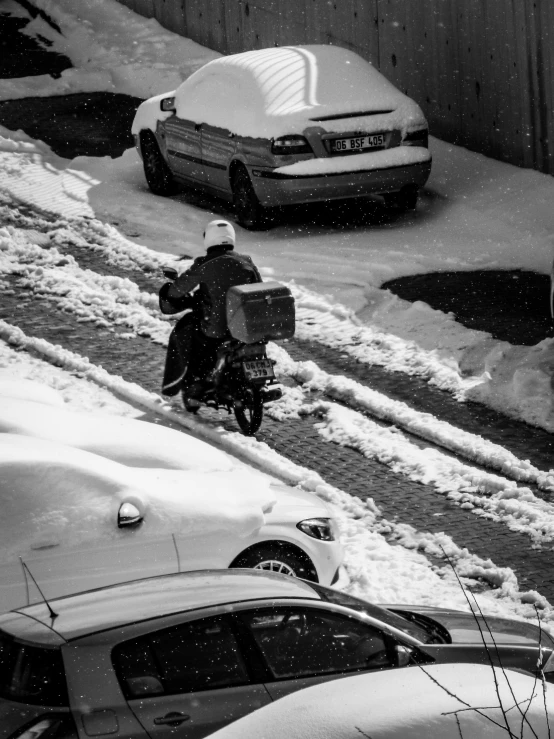 the person on the motor bike is traveling down a snowy road