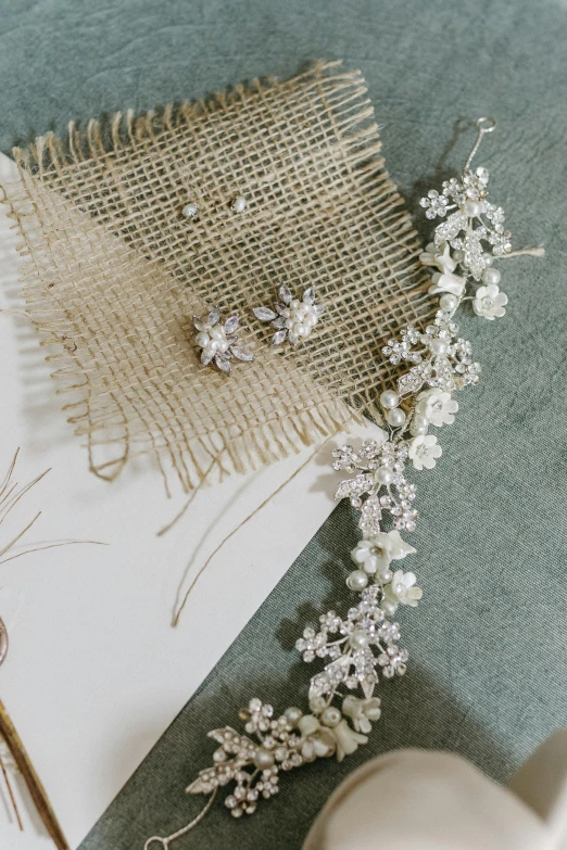 a pair of earrings on top of a piece of fabric