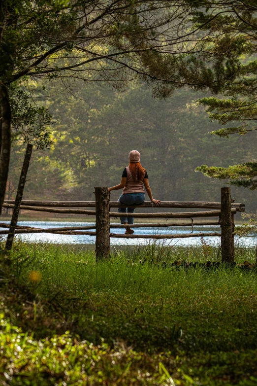 a person sitting on a bench by the water