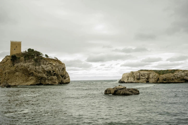 a castle sitting on top of a large rock next to the ocean