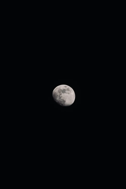 a moon is seen through the dark sky