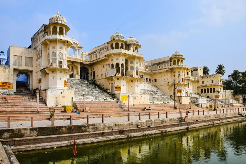 a building with many steps to it sitting next to a body of water