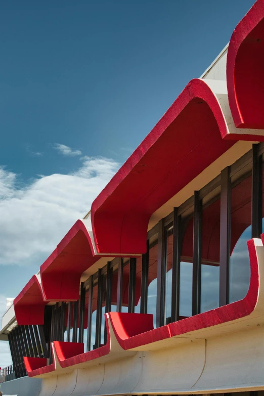 there is a red curved bench on the outside of a building