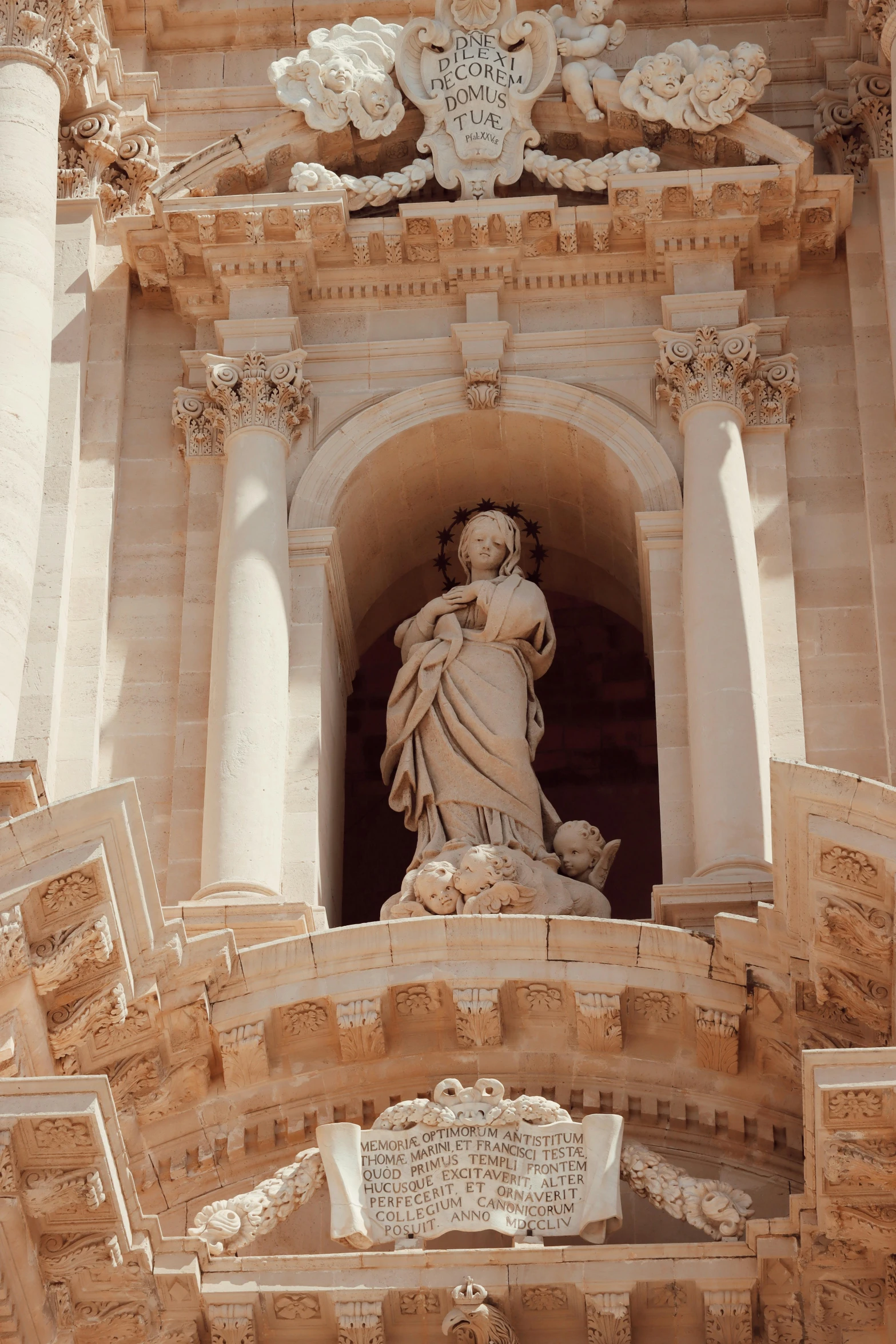 a large statue is on the top of a church tower