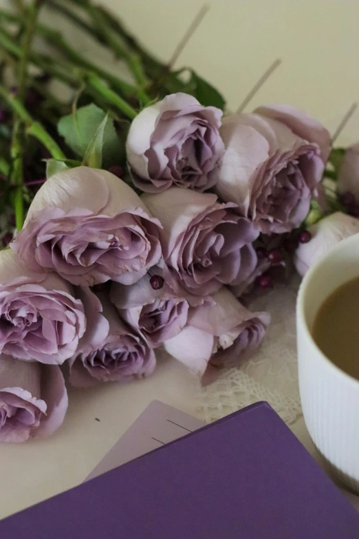 a bunch of purple flowers and some writing and a cup of coffee