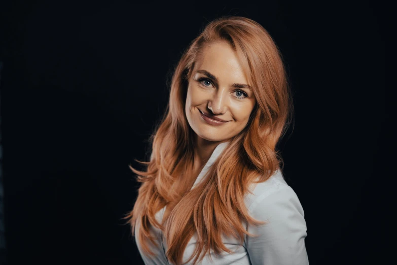 a woman with long, red hair is smiling