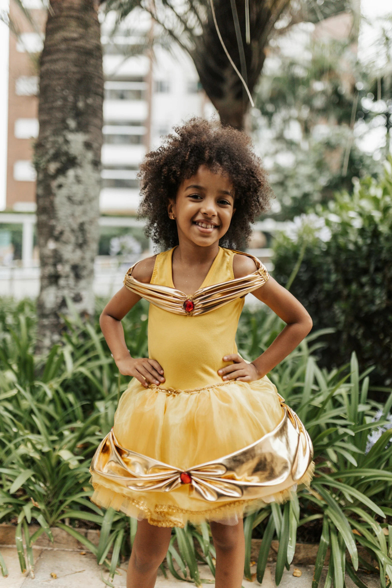 a  wearing a yellow dress standing on a street