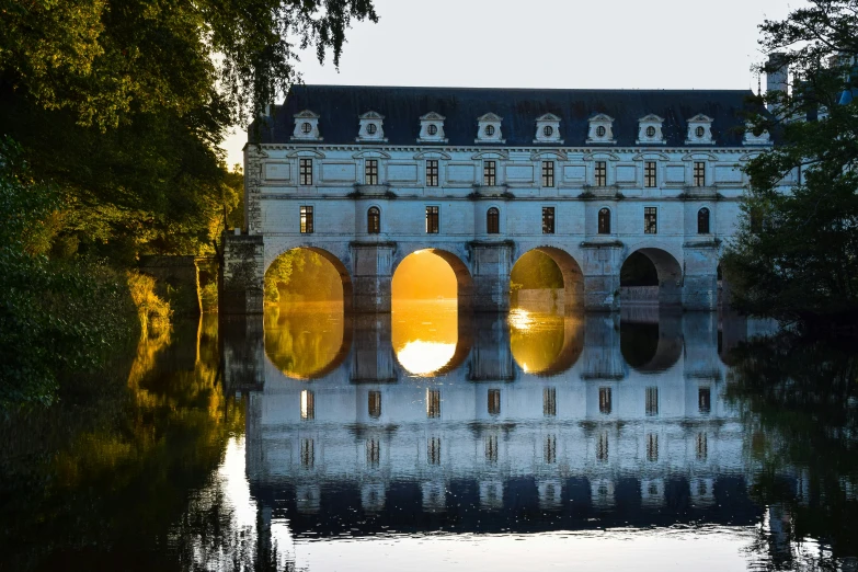 a castle with arched windows is reflected in the water