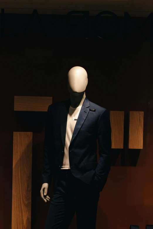 the mannequins wearing a suit stand in front of a wall