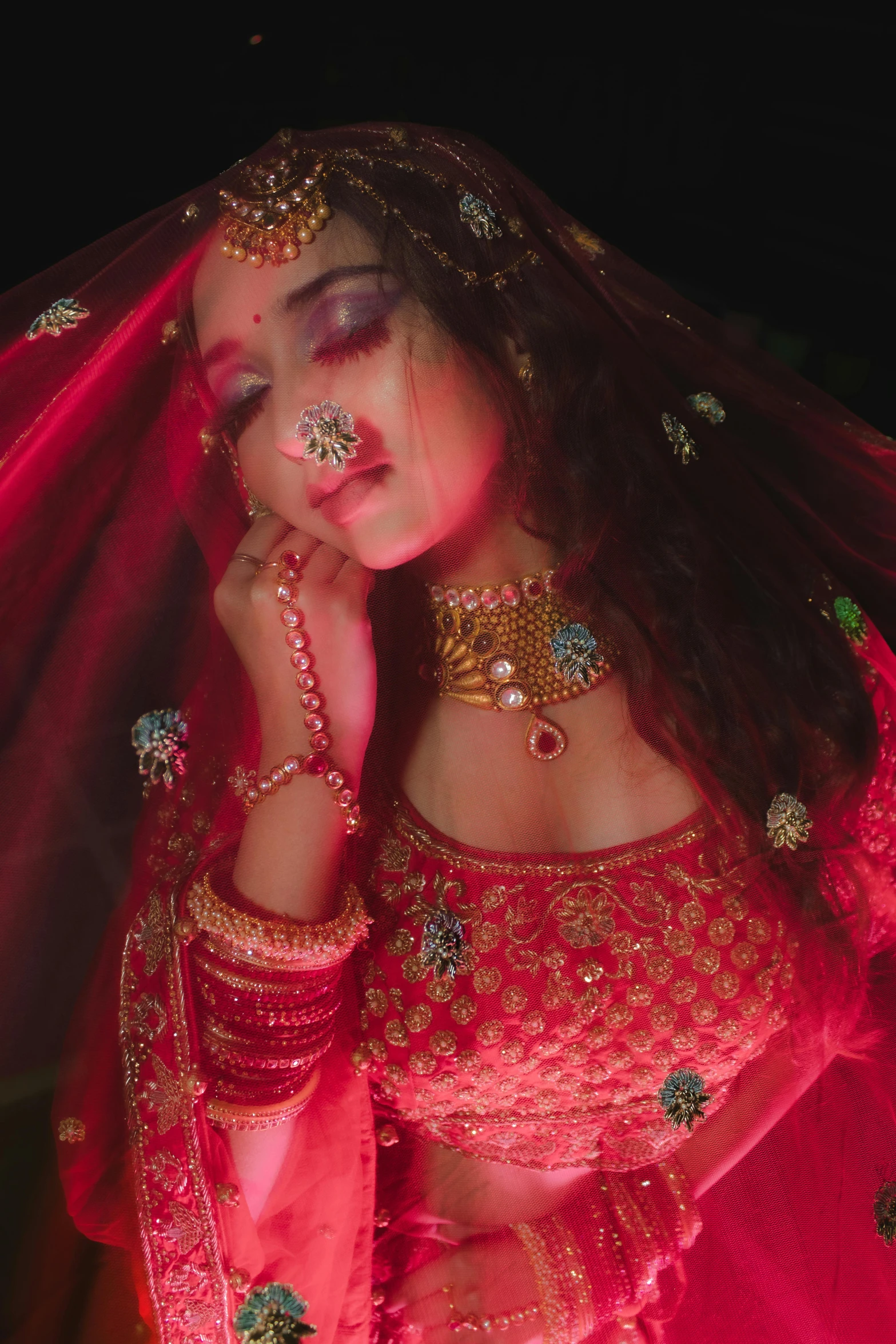 a woman with a veil and pink outfit posing