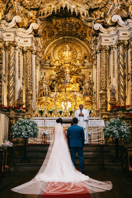 wedding pographer taking pictures at the alter as bride and groom stand near it