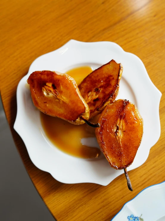 a white plate topped with sliced bananas next to syrup