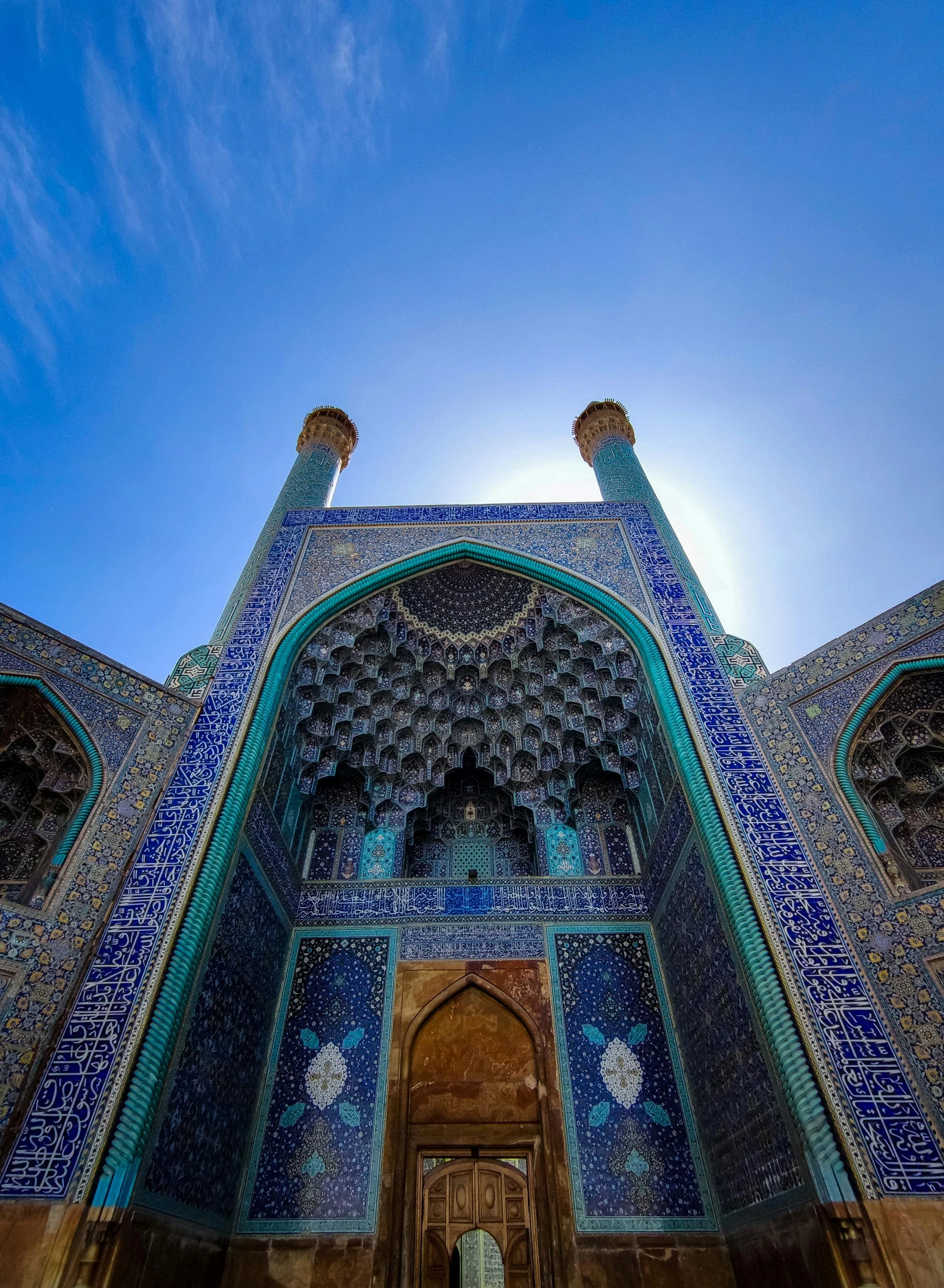 an intricately painted doorway is surrounded by blue tiled walls