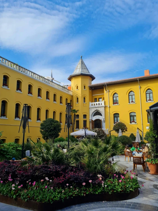 the courtyard of a building features many flowers and landscaping