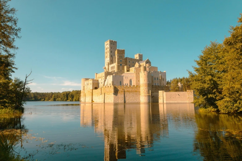 an old castle sitting on top of a lake surrounded by trees