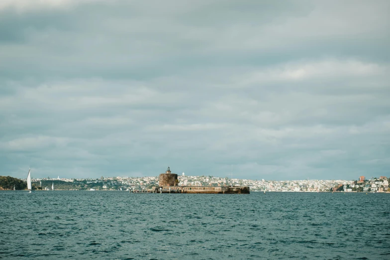 a body of water with a light house in the background