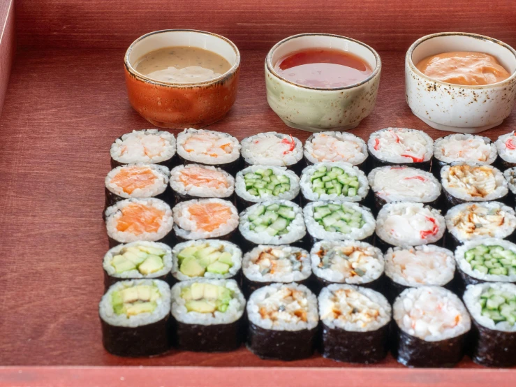 a red tray topped with lots of sushi