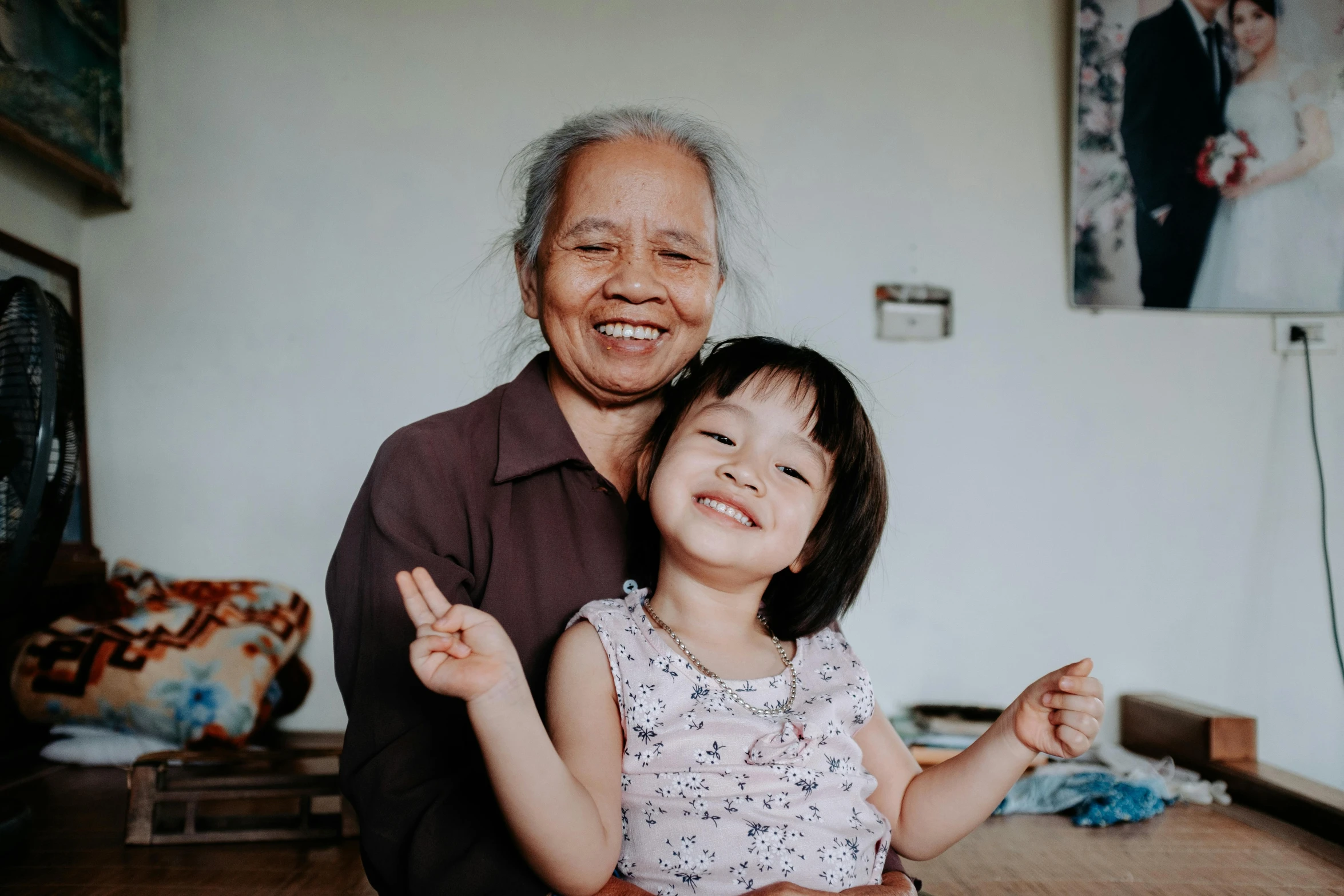 an old man holding a little girl, with two arms up in the air