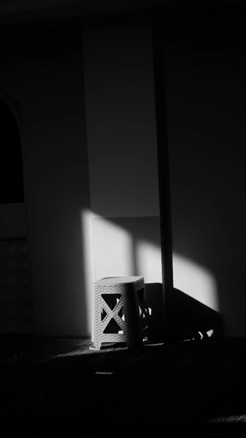 a black and white po of a bucket and the shadows of a doorway