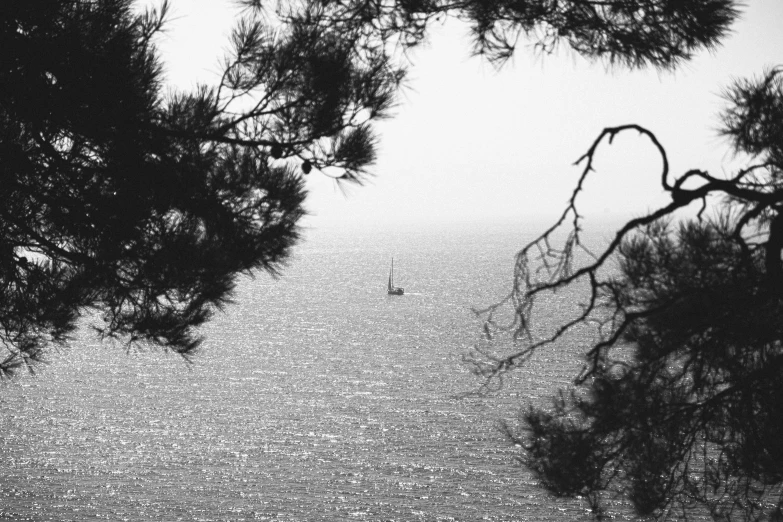 black and white pograph of sail boat on open ocean