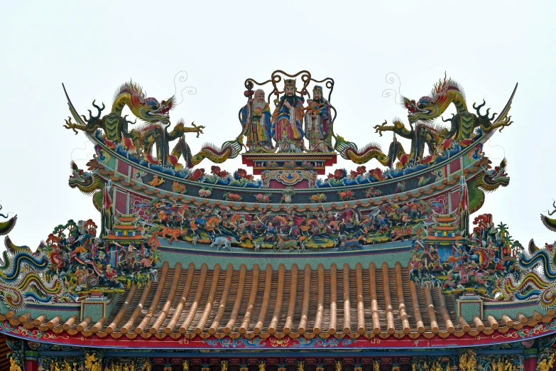 a view of an oriental building with dragon statues and gargonets on top