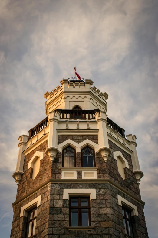 an old brick building has a tower with three balconies