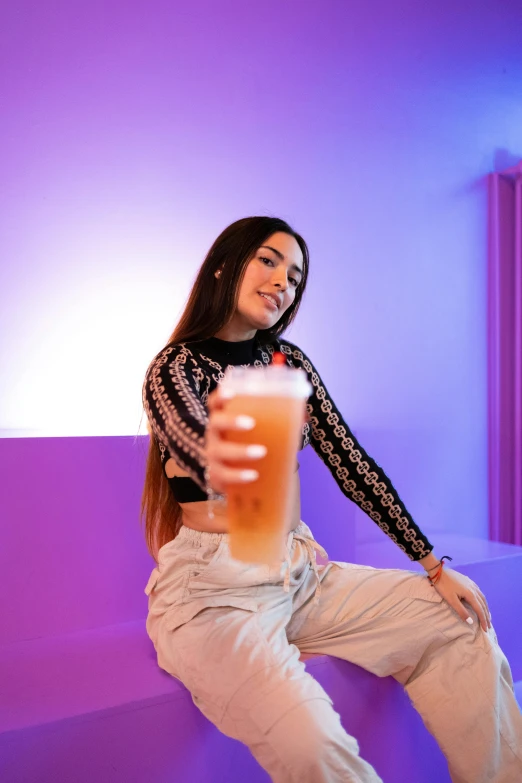 a girl is sitting on the ground with a pint of beer