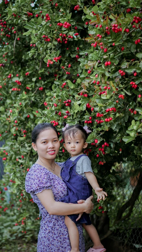 an adult and child standing next to each other under a bunch of tree