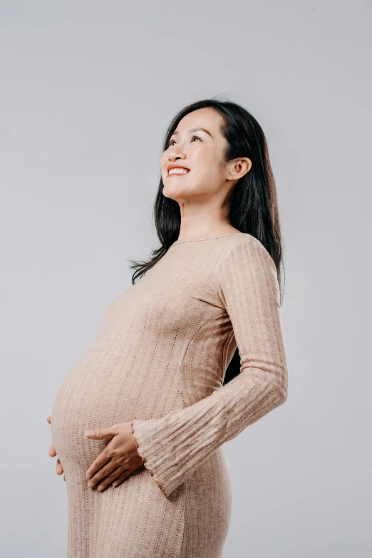 a pregnant woman looking upward to her left side