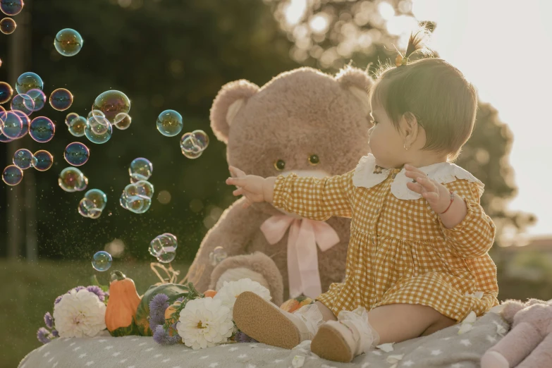 a child in a yellow shirt plays with bubbles